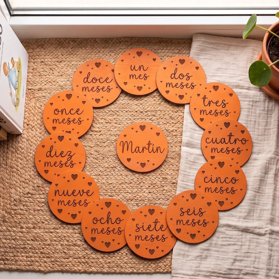 Tarjetas redondas de cumplemés con el mes en letra caligráfica grabada y corazones a su alrededor