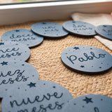Cumplemés personalizado con estrellas grabadas y el nombre del bebé en la tarjeta central