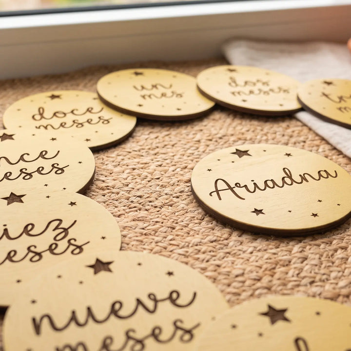 Siete tarjetas de cumplemés con estrellas grabadas sobre una tela de lino en una habitación infantil