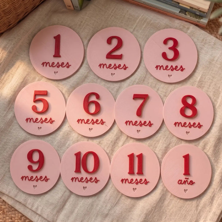 Doce tarjetas redondas de cumplemés combinando el color de la placa con el del número en relieve