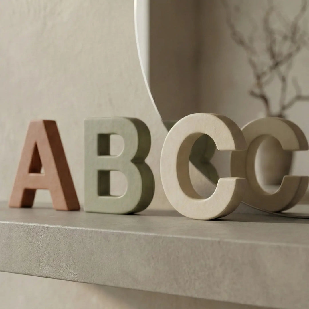 Letras de juguete dispersas sobre mesa de madera clara mostrando profundidad y variedad de colores.