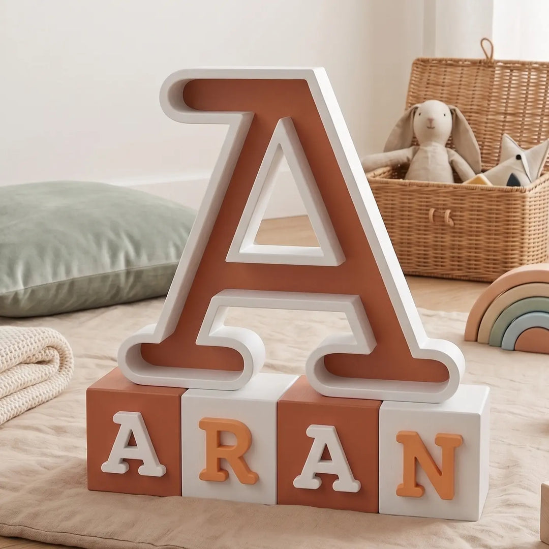 Letra A personalizada en terracota y blanco sobre cuatro bloques con el nombre Aran