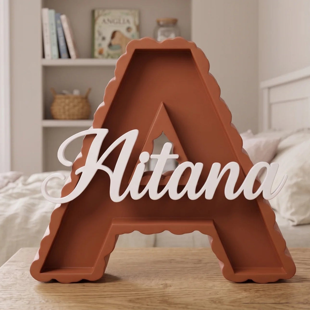 Letra A en terracota con el nombre Aitana sobre una mesa de madera en una habitación de bebé