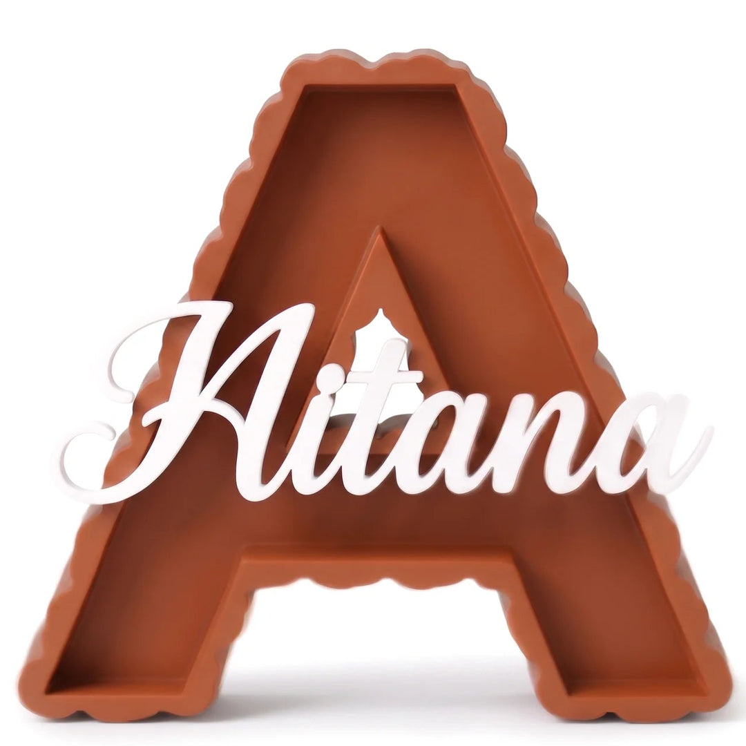 Letra A de borde en gotas en terracota con el nombre Aitana en caligrafía blanca