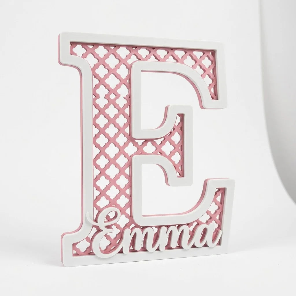 Letra E decorativa infantil con celosía marroquí calada en rosa sakura, marco blanco y el nombre Emma, sobre fondo blanco