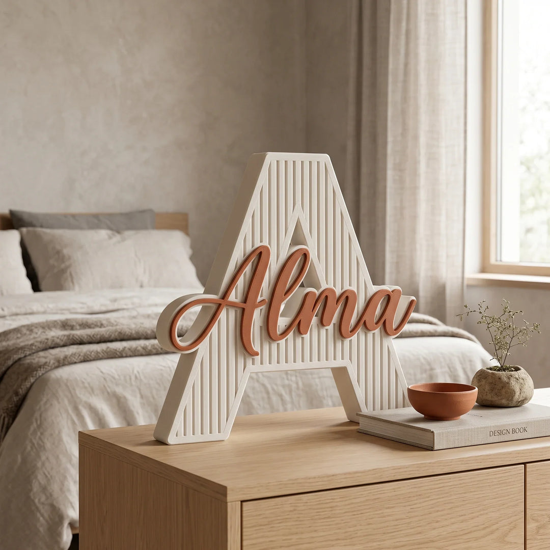 Letra A personalizada Acanalada sobre una cómoda de madera clara en un dormitorio japandí
