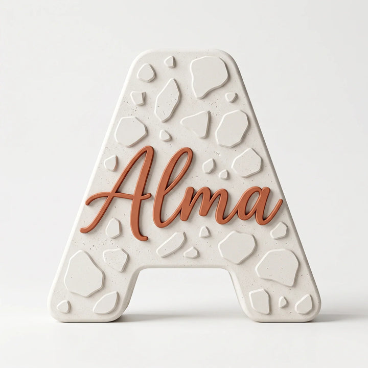 Letra A personalizada Terrazo con el nombre Alma en relieve, sobre fondo blanco