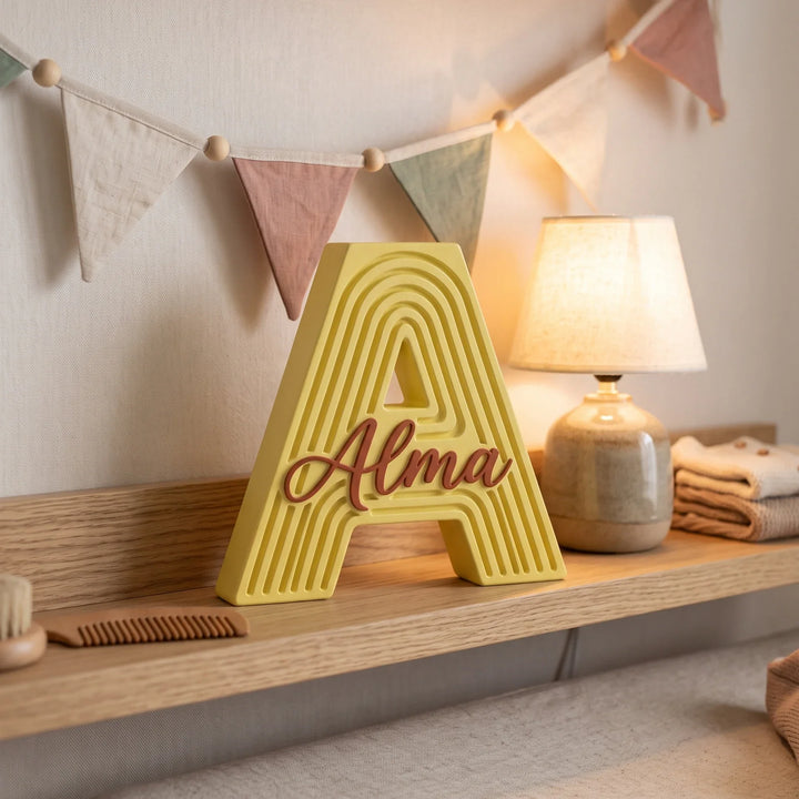 Letra A personalizada Arcoíris en amarillo sobre un estante con guirnalda de banderines