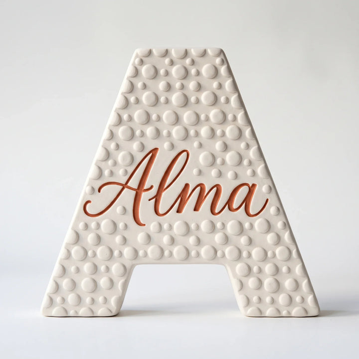 Letra A personalizada Lunares con el nombre Alma en relieve, sobre fondo blanco