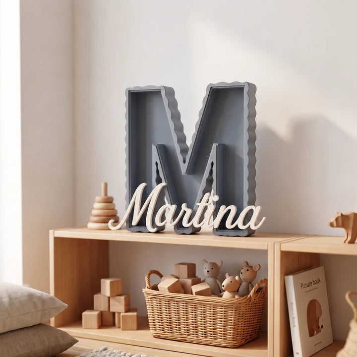 Letra M personalizada de borde ondulado en azul gris con el nombre Martina en caligrafía